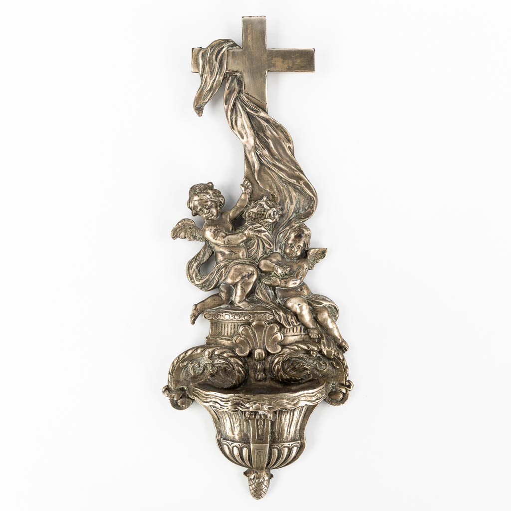 Een wijwatervat in Barokke stijl, Engelenfiguren en een crucifix. Verzilverd brons. 19de eeuw.