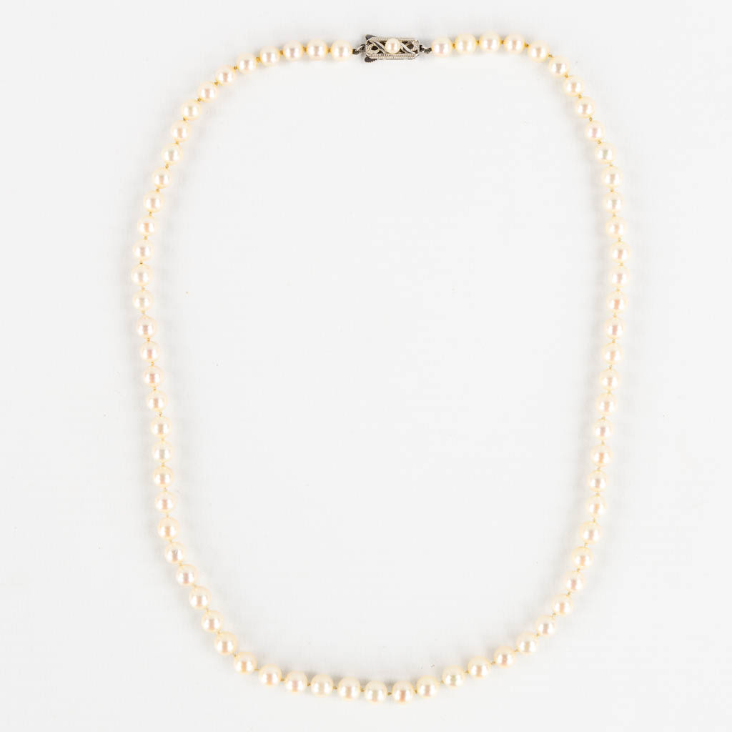 Mikimoto, a pearl necklace and tie clasp, 14kt white and yellow gold, 1965. 