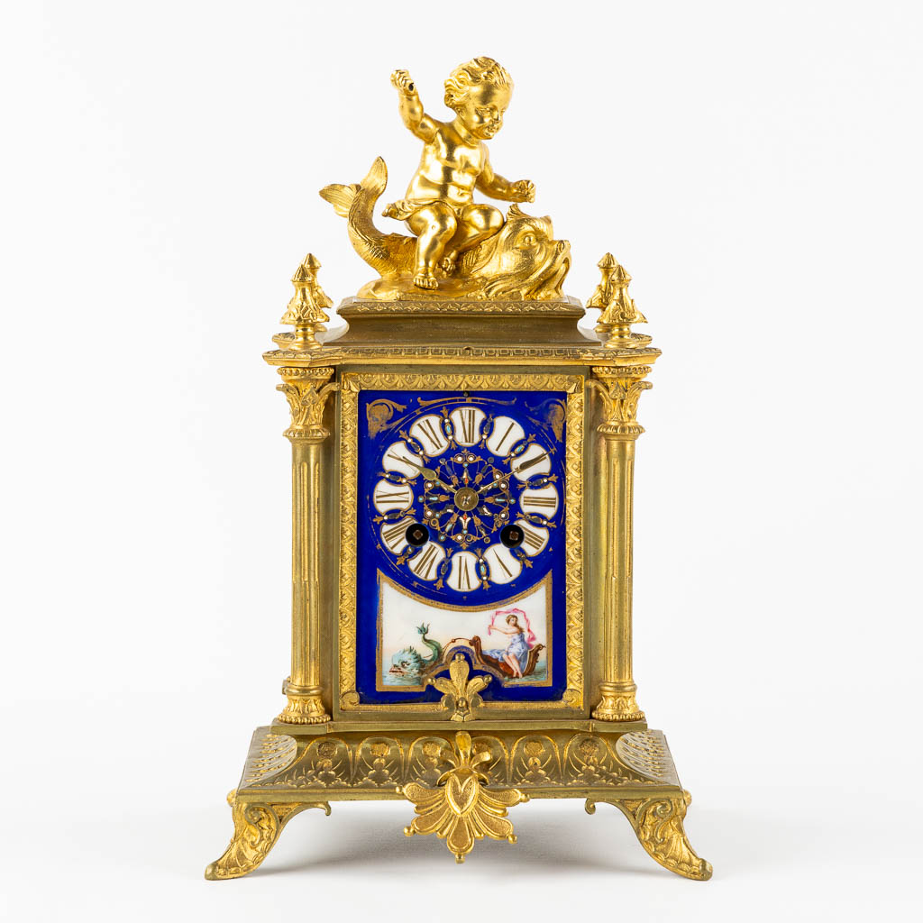 A mantle clock, gilt bronze mounted with porcelain. 19th C.