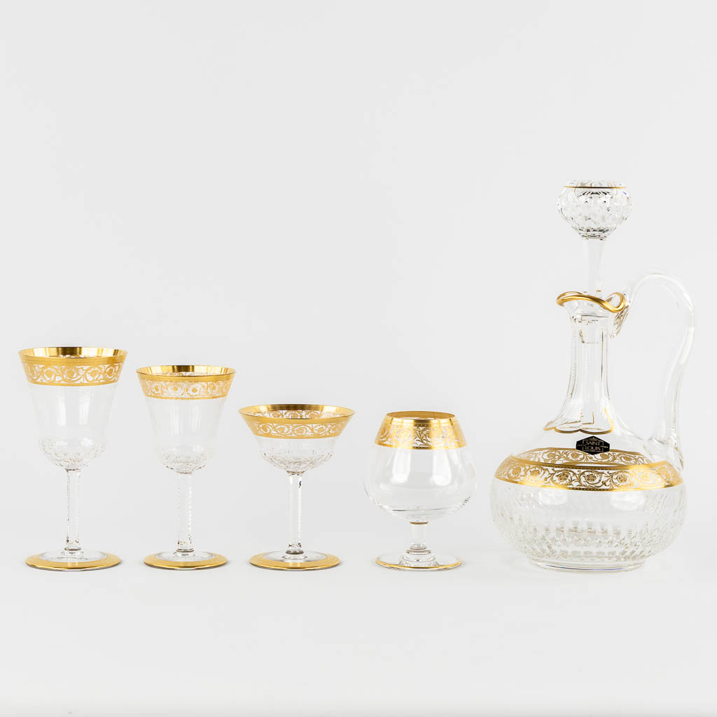 Saint Louis, a 27-piece glass service. Goblets and a carafe, gilt crystal. (H:32 cm)