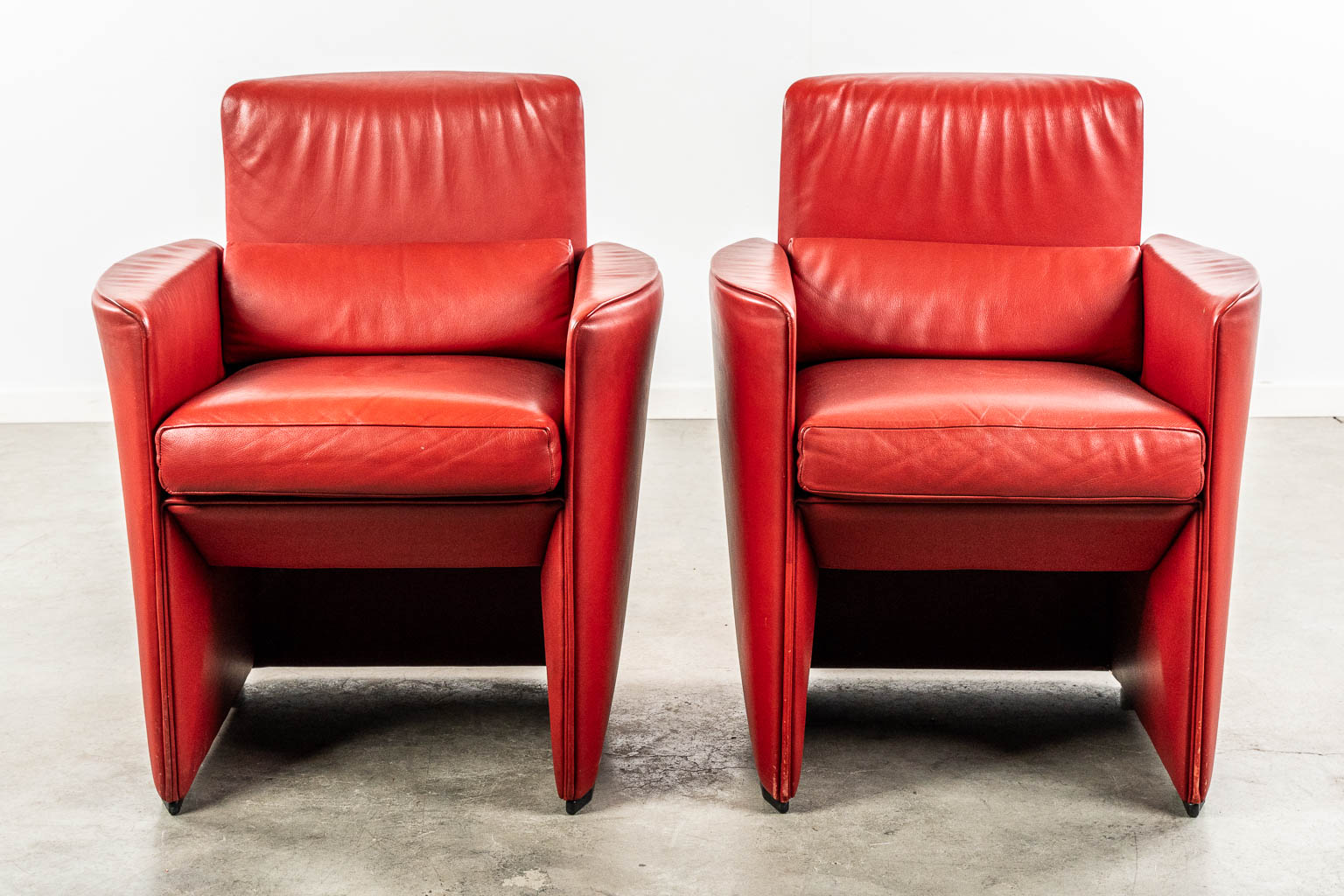 DeSede, Switserland, A pair of two red leather armchairs. (L:64 x W:66 x H:83 cm)