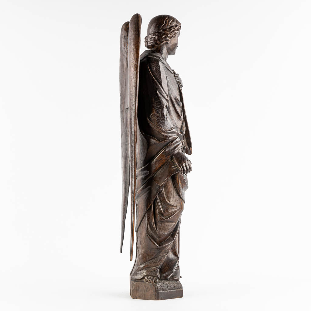 A large wood sculptured figurine of an angel, oak, 19th C. (L:20 x W:40 x H:95 cm)