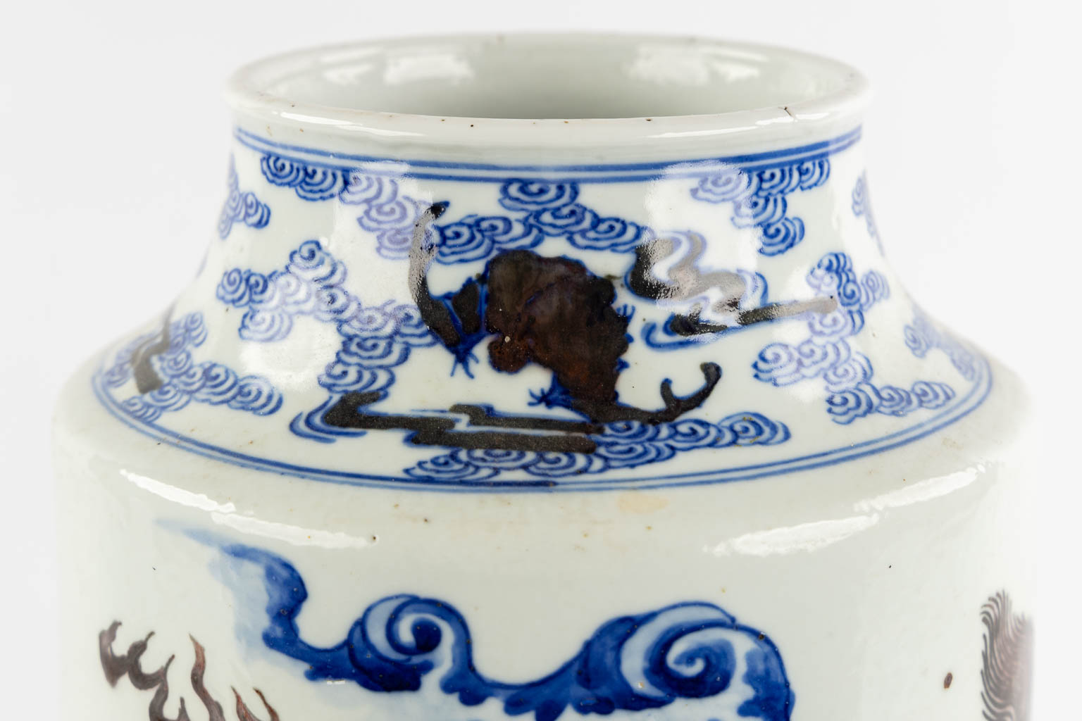 A Chinese Rouleau vase with a blue, black and white Foo Dog. Kangxi mark, 19th C. (H:39 x D:29 cm)