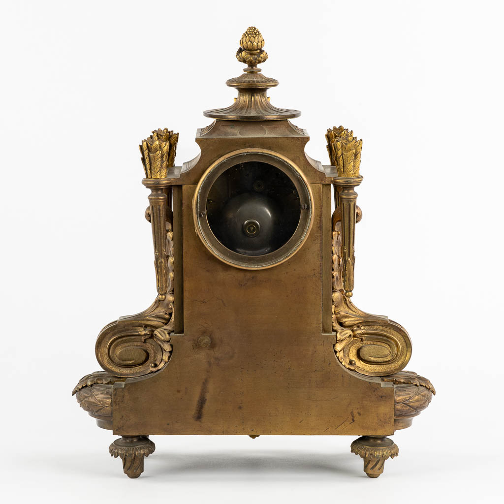 A mantle clock, gilt bronze in a Louis XVI style. Circa 1900. (L:16 x W:32 x H:41 cm)