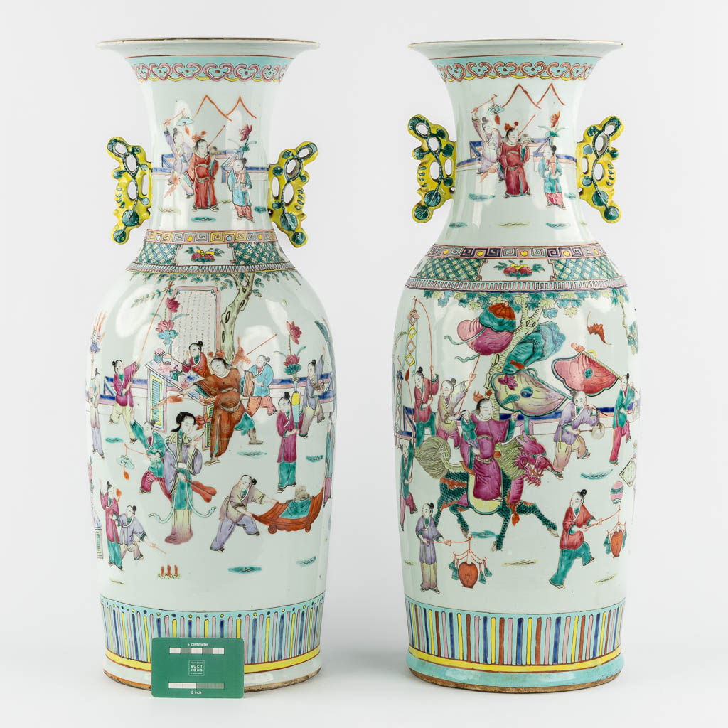 A pair of Chinese Famille Rose vases decorated with various figurines. (H:60 x D:23 cm)