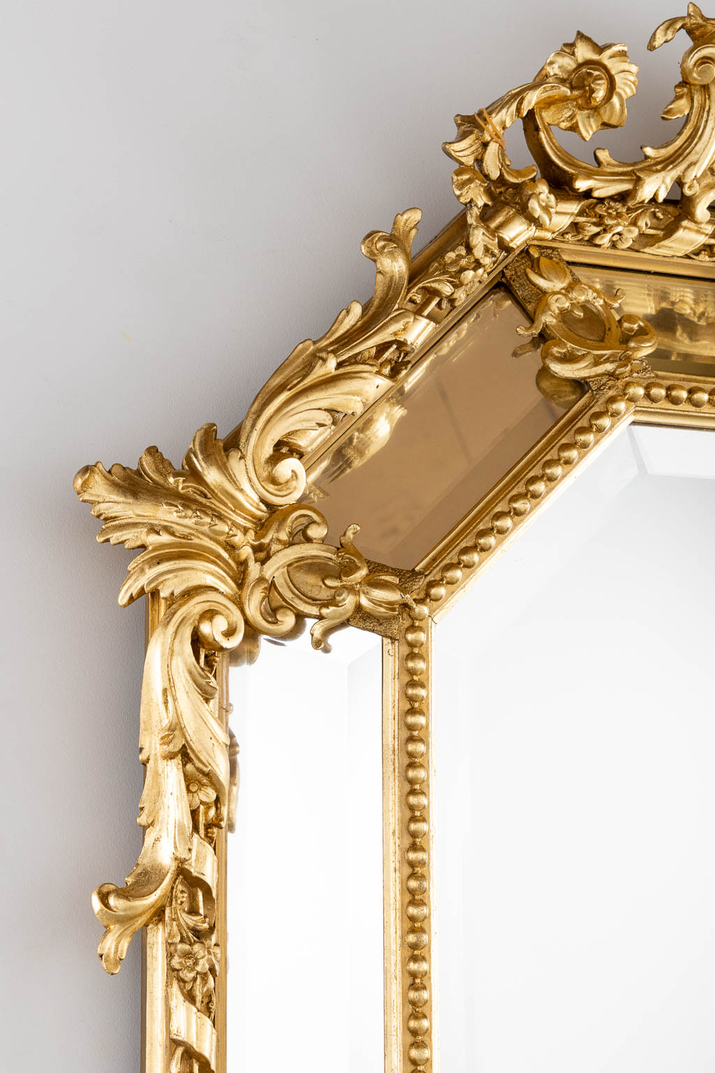 An antique mirror, sculptured gilt stucco and facetted glass, Louis XV style. 19th C. (W:98 x H:140 cm)