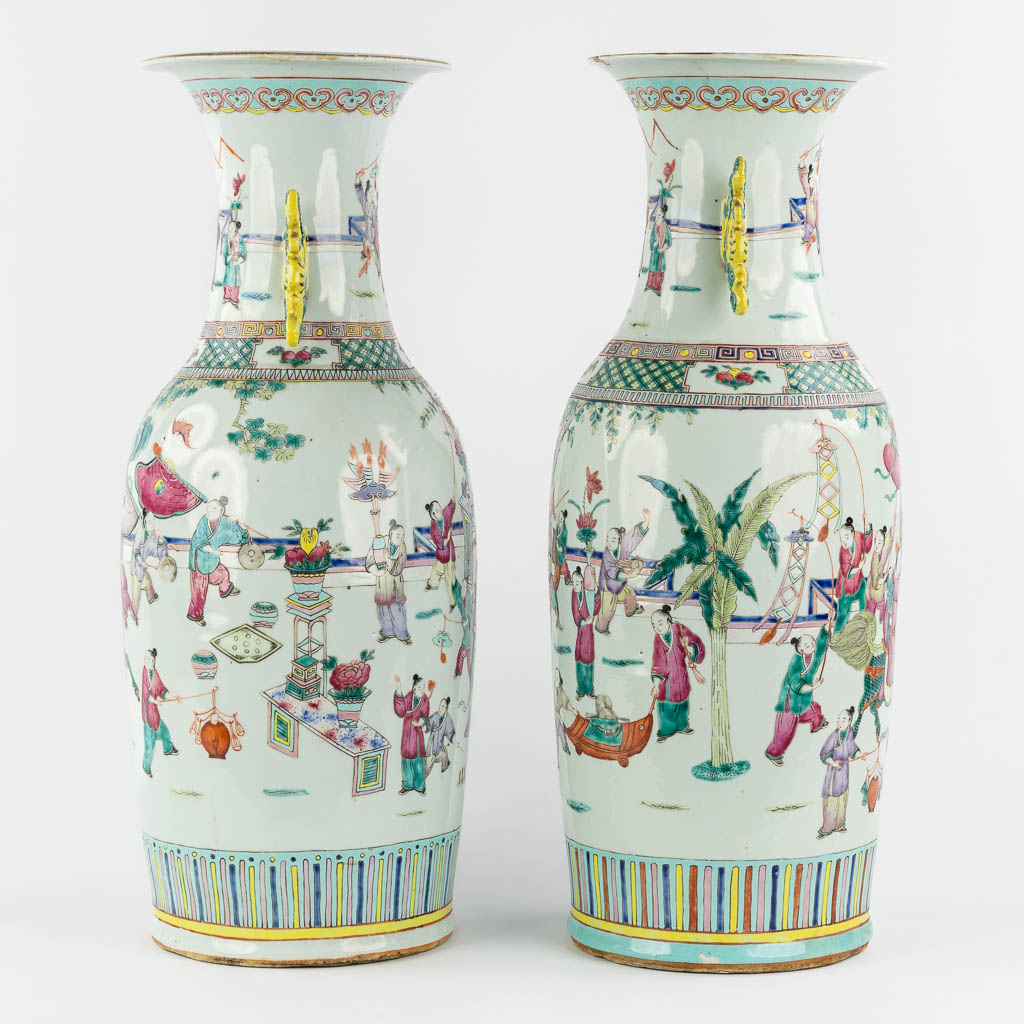 A pair of Chinese Famille Rose vases decorated with various figurines. (H:60 x D:23 cm)