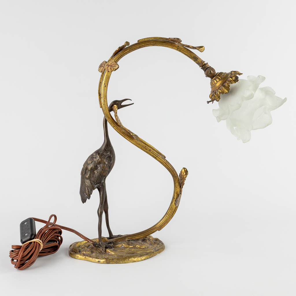 A table lamp with a large bird, probably a Heron. Patinated and gilt bronze, circa 1900. (W:33 x H:37 cm)