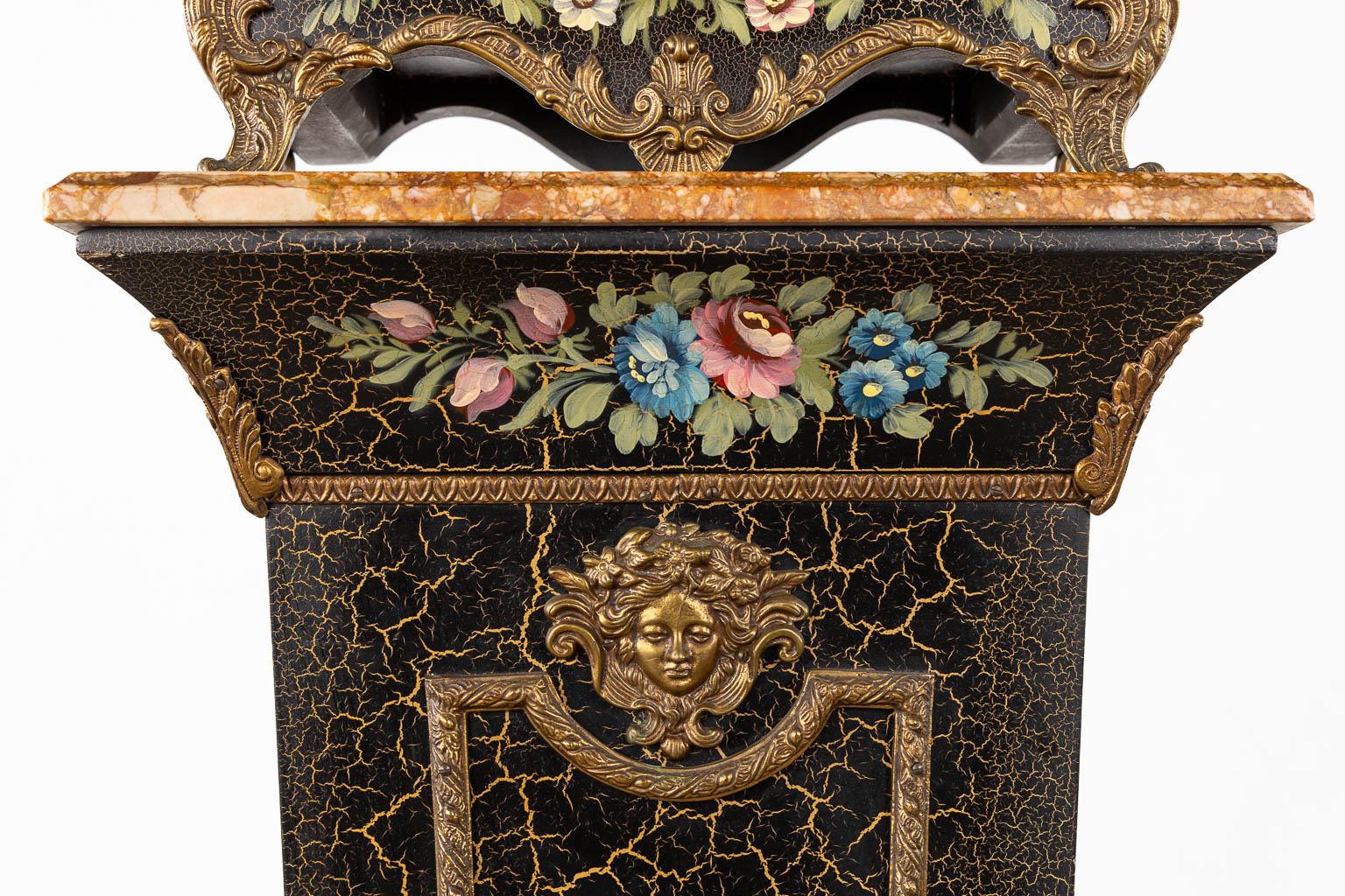 A cartel clock on a base, floral decor and mounted with putti. 20th C. (L:25 x W:44 x H:193 cm)