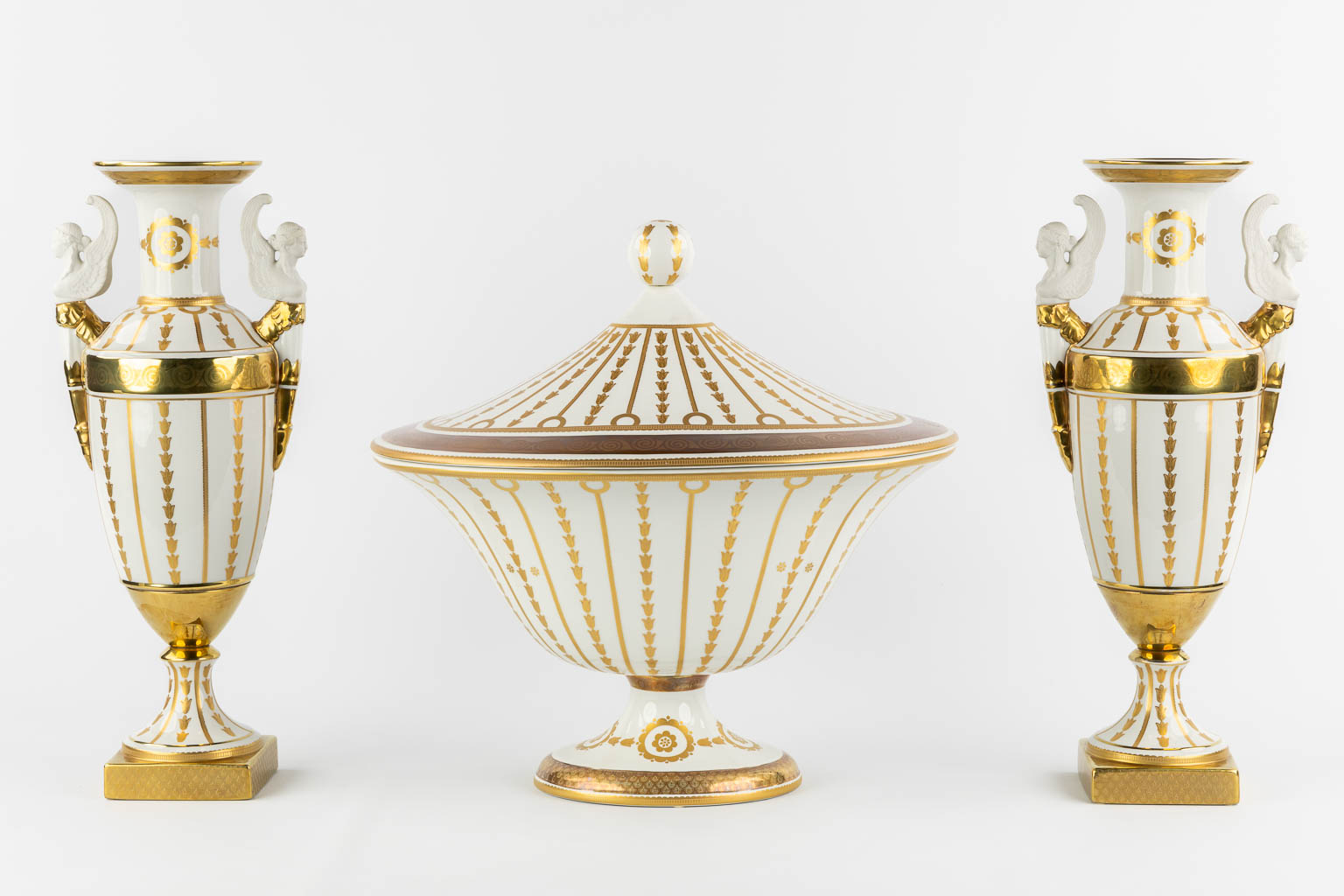 Mangani, Italy, a three-piece garniture, gilt porcelain in Empire style. (L:32 x W:43 x H:40 cm)