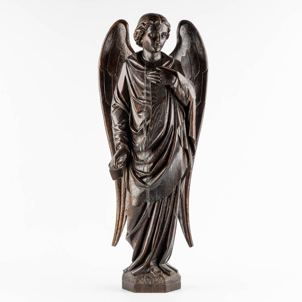 A large wood sculptured figurine of an angel, oak, 19th C. (L:20 x W:40 x H:95 cm)