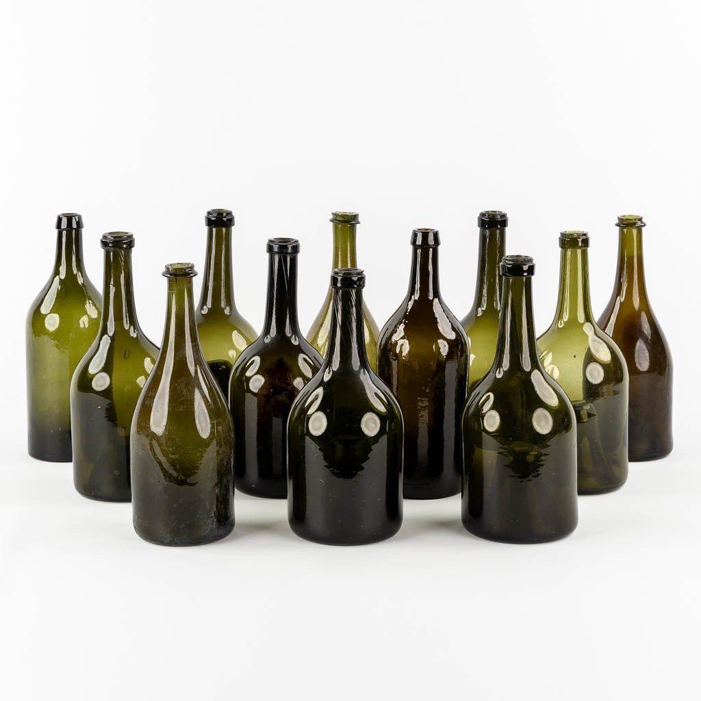 Twelve antique glass bottles, olive green glass. 18th and 19th C.