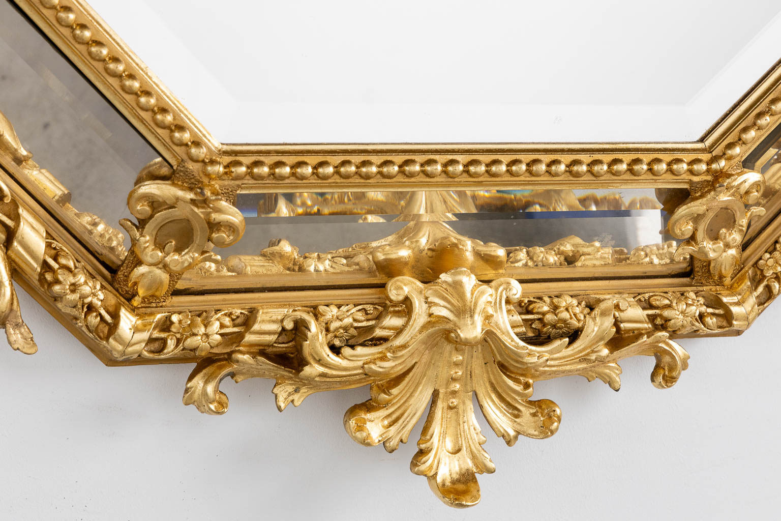 An antique mirror, sculptured gilt stucco and facetted glass, Louis XV style. 19th C. (W:98 x H:140 cm)