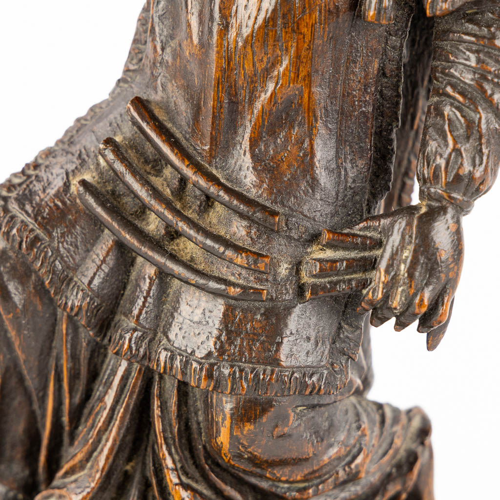 An antique wood-sculptured figurine of a saint holding a scourge. 17th C. (W:10 x H:29 cm)