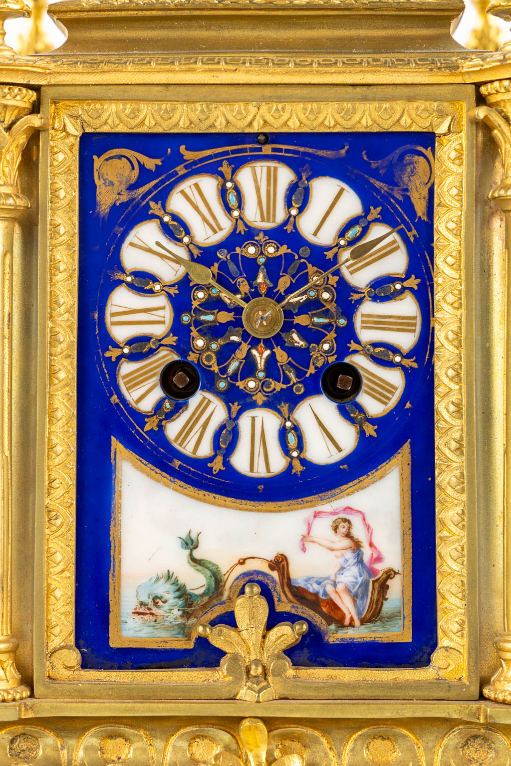 A mantle clock, gilt bronze mounted with porcelain. 19th C.