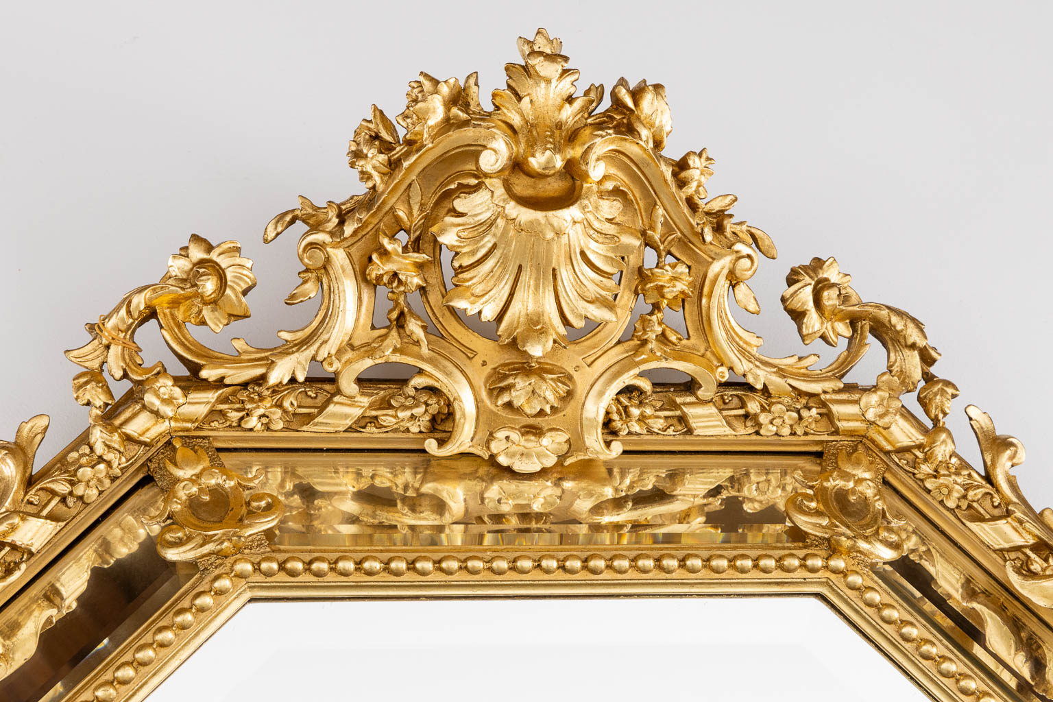 An antique mirror, sculptured gilt stucco and facetted glass, Louis XV style. 19th C. (W:98 x H:140 cm)