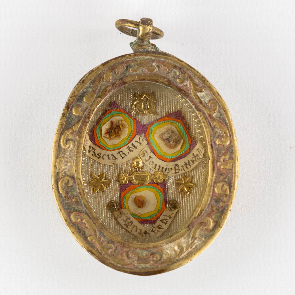 A sealed reliquary hanger with 3 relics, Ex Pascis, BMV, Saint John The Bapstist. (W:4,5 x H:6,5 cm)