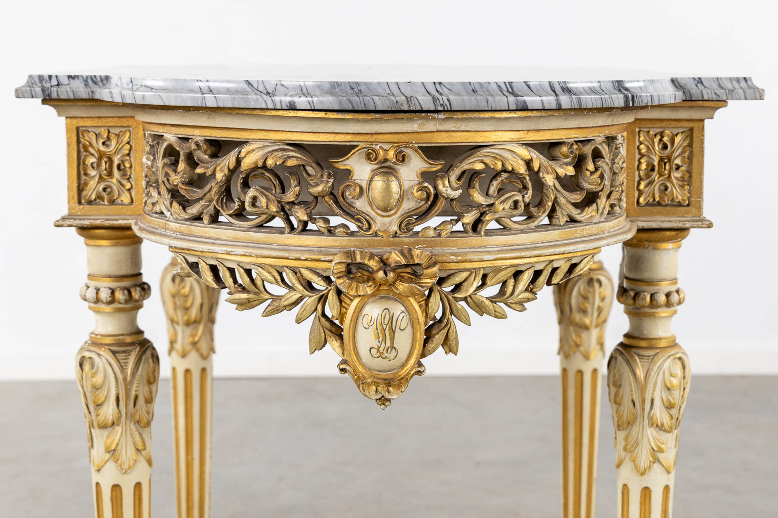 A wood-sculptured and patinated table with a grey marble, Louis XVI style. (L:65 x W:112 x H:80 cm)