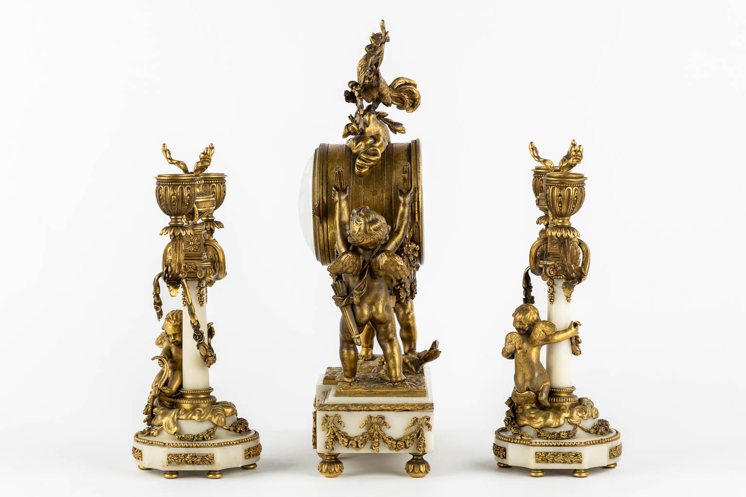 A three-piece mantle garniture clock and candelabra, bronze and marble, 19th C. (L:11 x W:27 x H:36 cm)