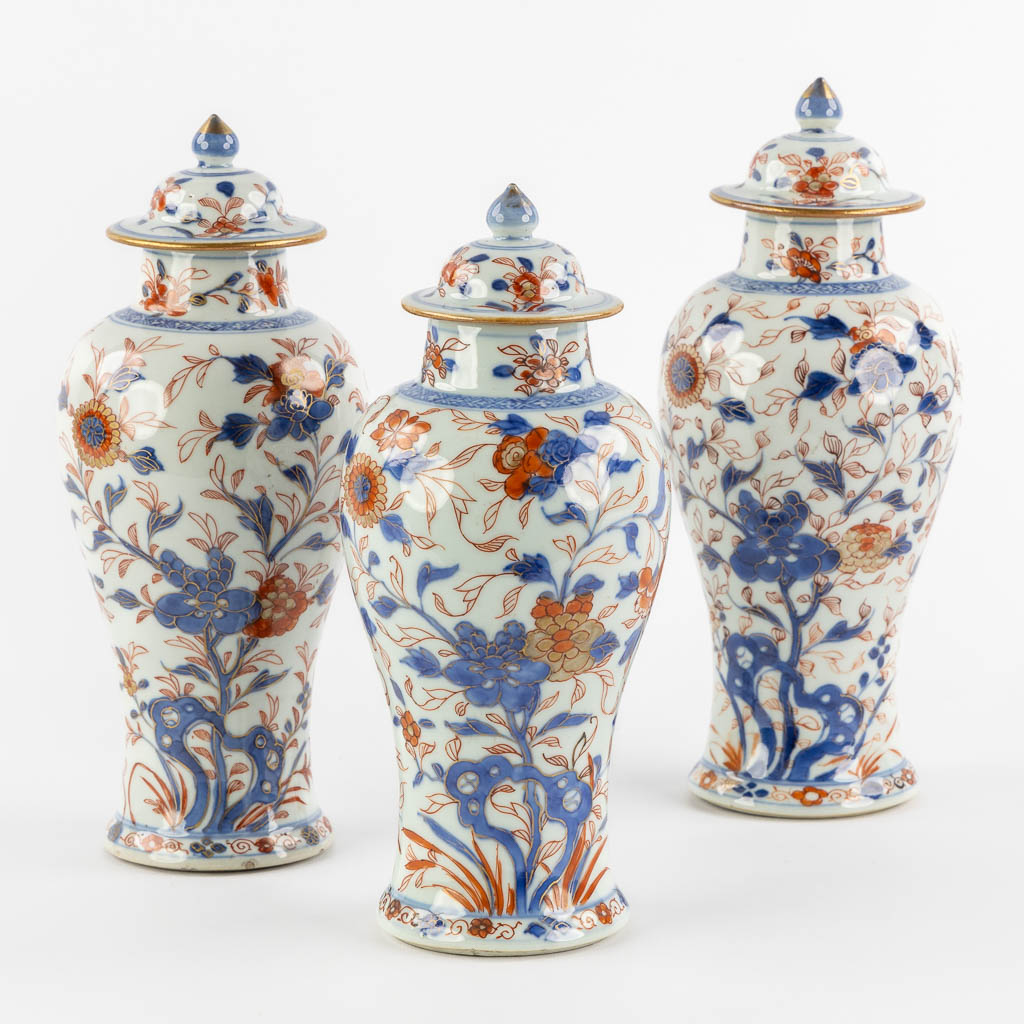 Drie Chinese Imari stijl vazen met een deksel en floraal decor, Kangxi. (H:27 x D:11 cm)