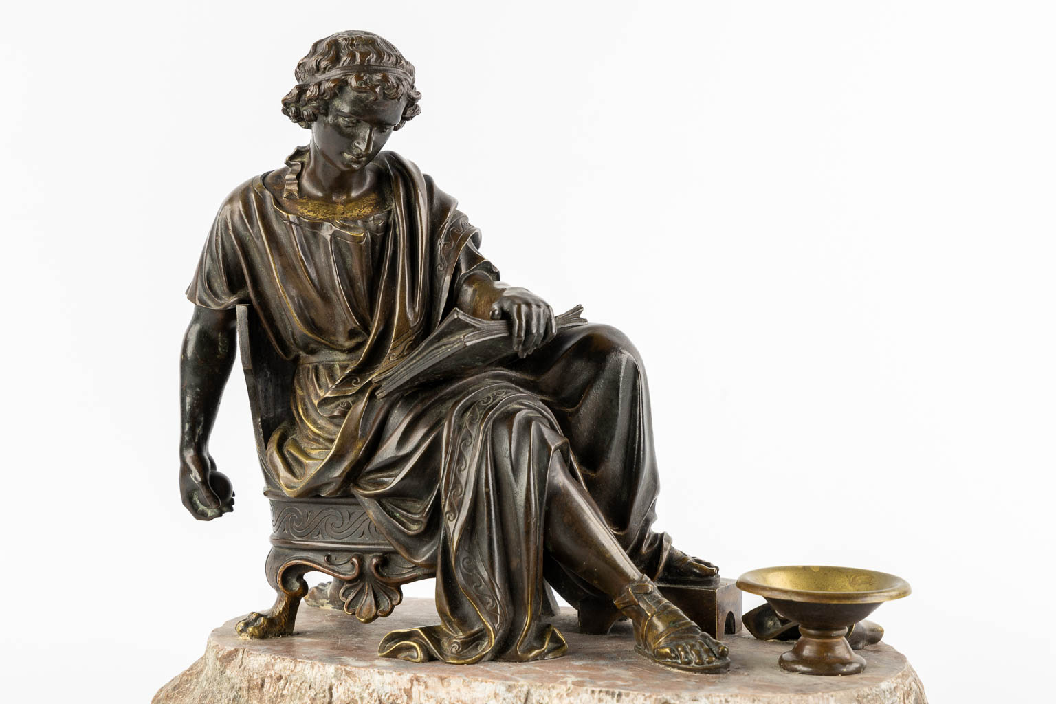 The Reading Roman, patinated bronze. 19th C. (L:23 x W:38 x H:34 cm)