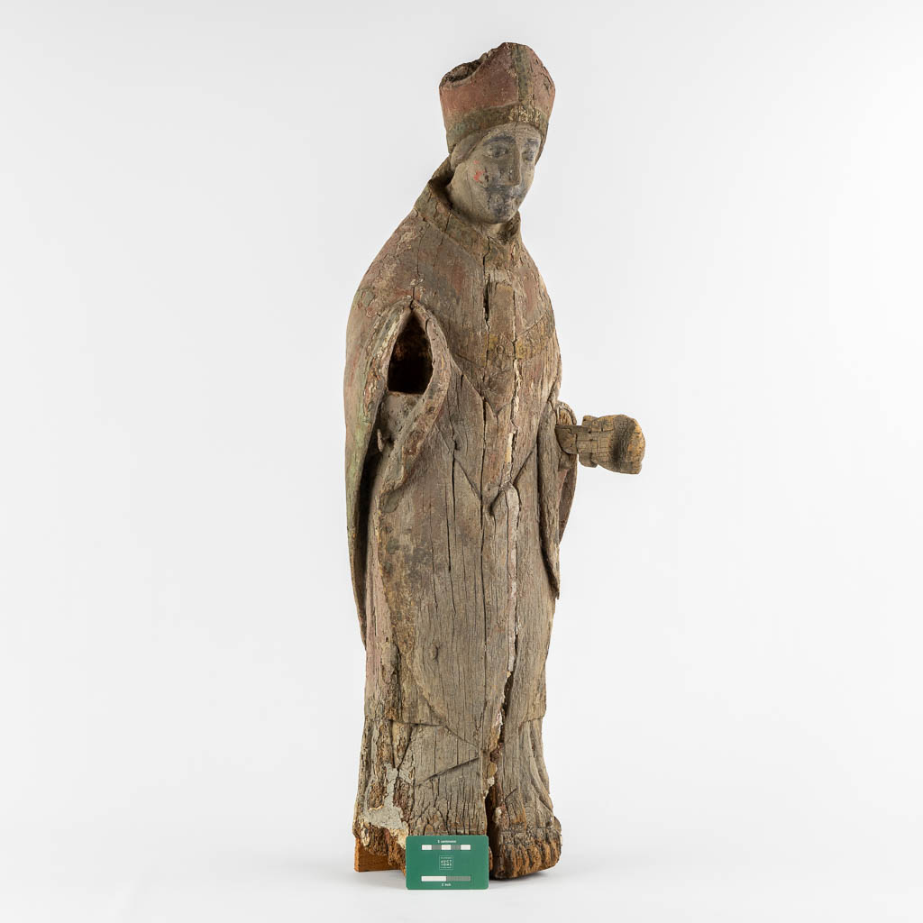 An antique wood-sculptured figurine of a Bishop, Roman, mid-13th/early 14th C. (L:23 x W:27 x H:88 cm)