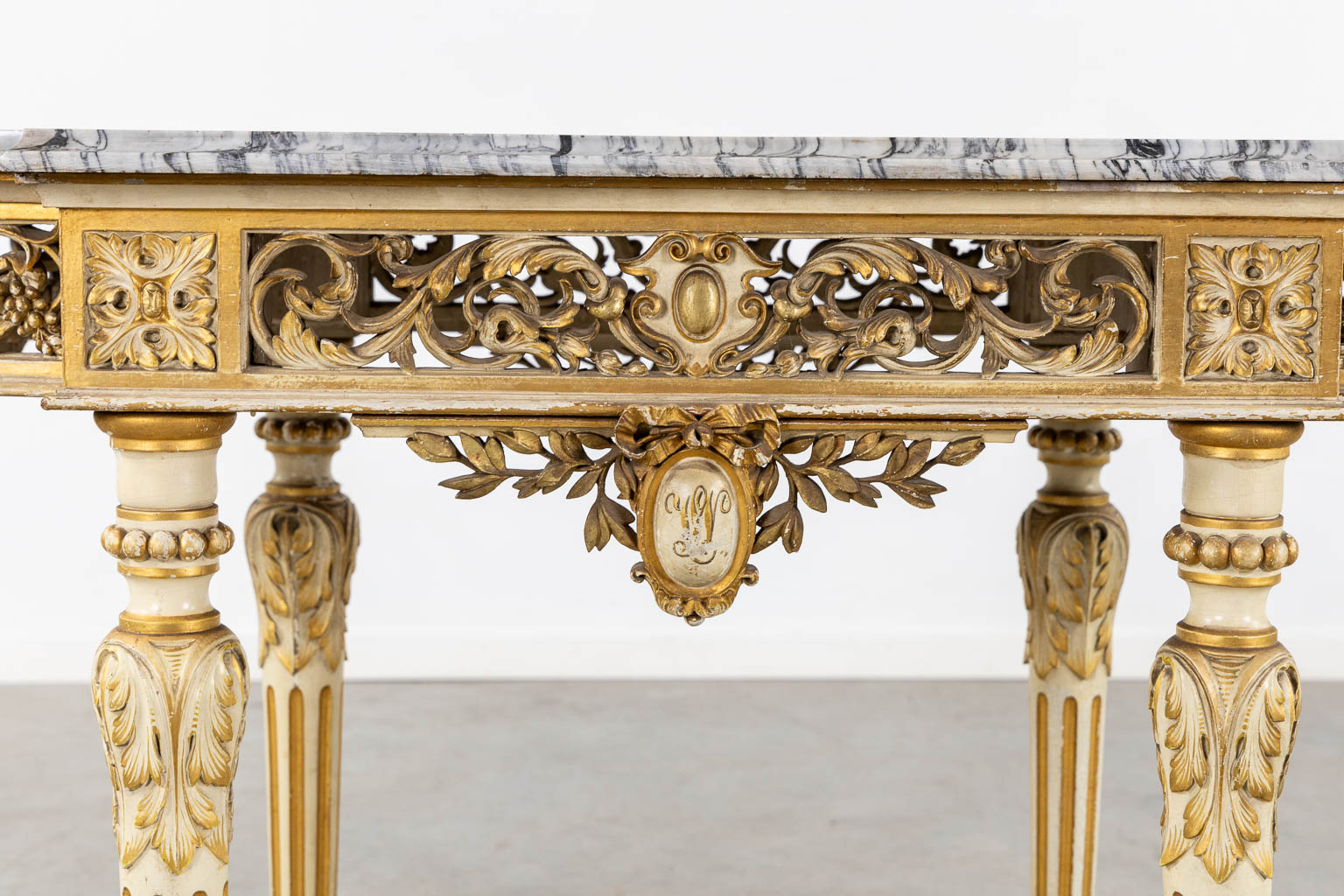 A wood-sculptured and patinated table with a grey marble, Louis XVI style. (L:65 x W:112 x H:80 cm)