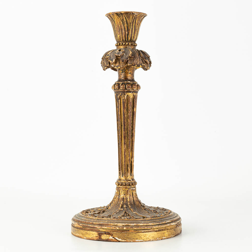 An antique candlestick made of sculptured wood