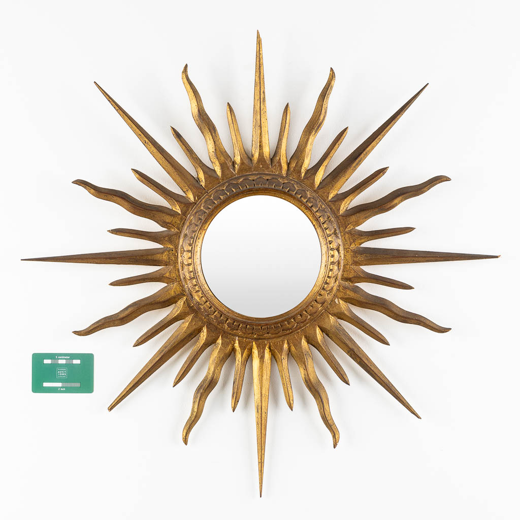 A sunburst mirror, gilt and sculptured wood. (D:66 cm)