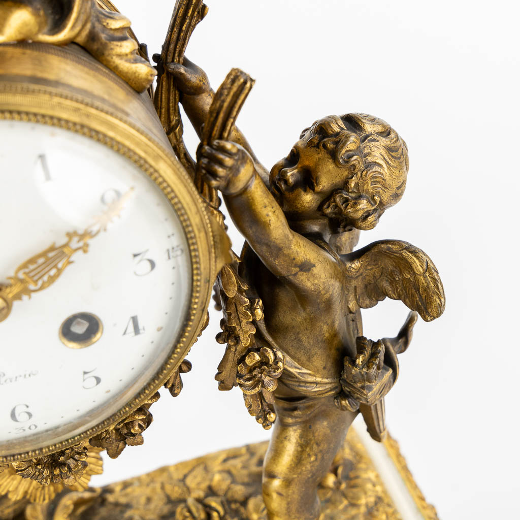 A three-piece mantle garniture clock and candelabra, bronze and marble, 19th C. (L:11 x W:27 x H:36 cm)