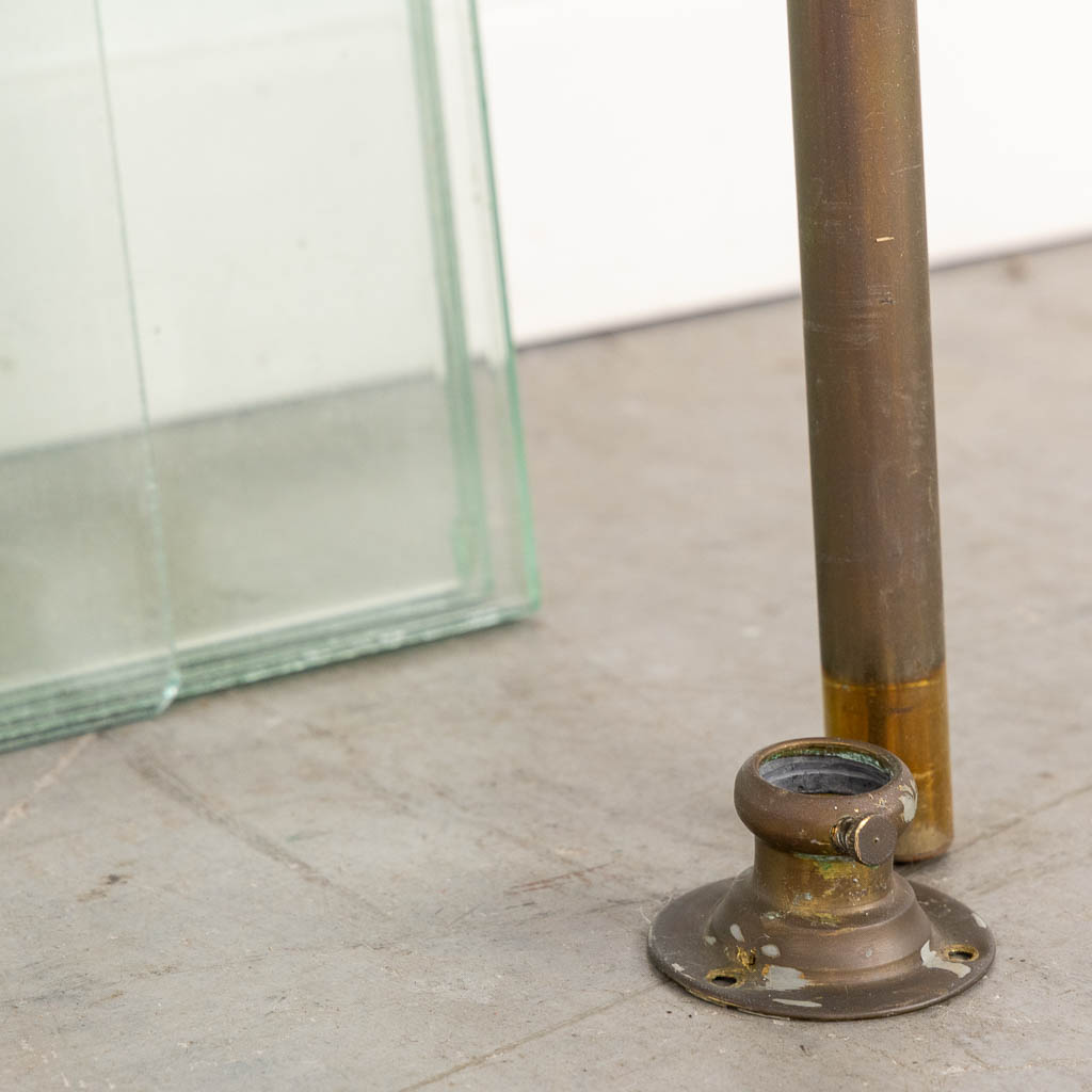 A display rack, brass, glass and plexiglass. Circa 1920. (W:37,5 x H:182 cm)