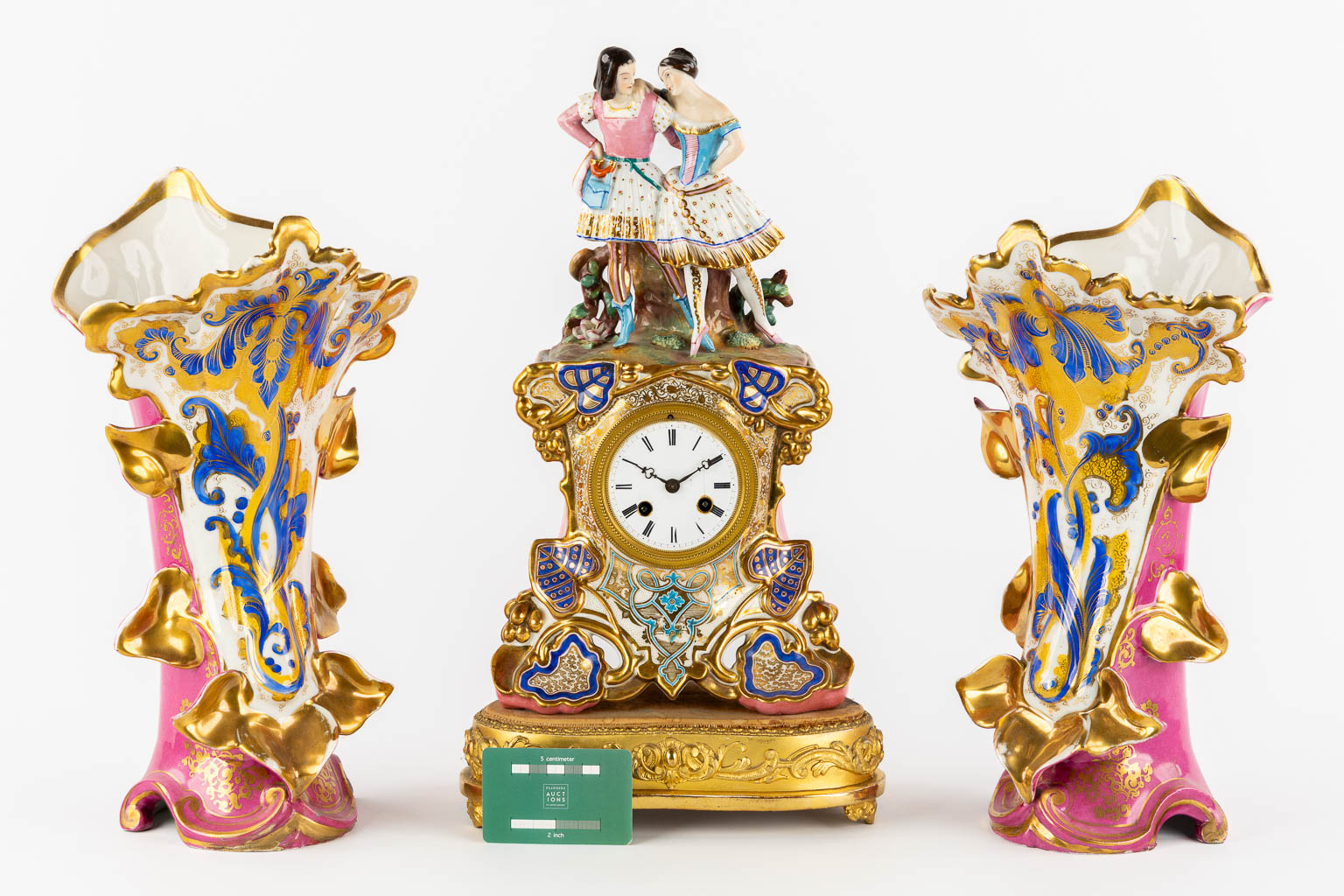 A three-piece mantle garniture clock and side pieces, polychrome porcelain in the style of Jacob Petit. 19th C.