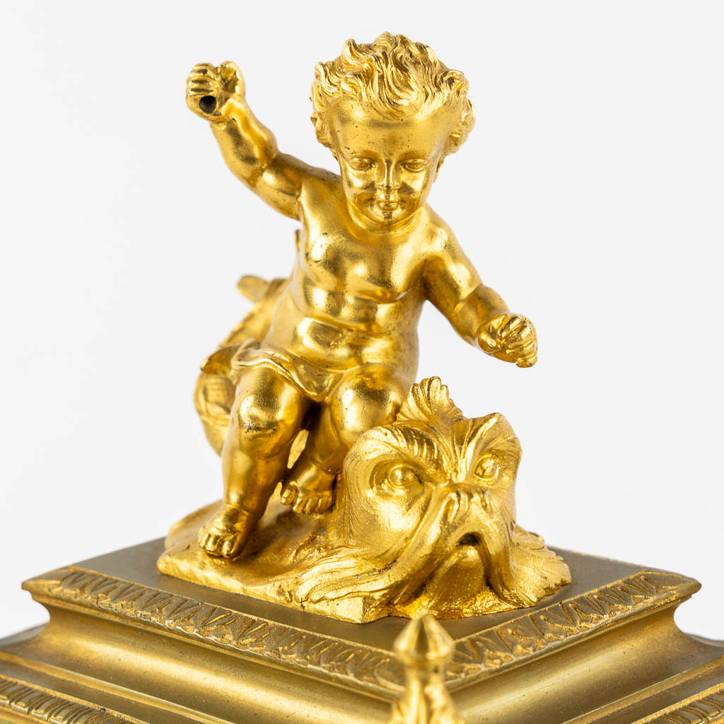 A mantle clock, gilt bronze mounted with porcelain. 19th C.