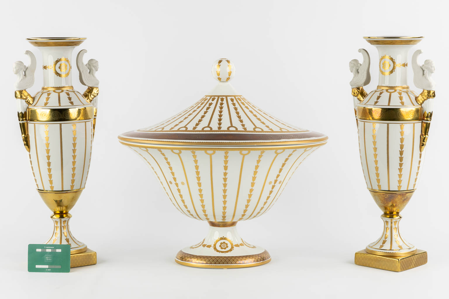 Mangani, Italy, a three-piece garniture, gilt porcelain in Empire style. (L:32 x W:43 x H:40 cm)