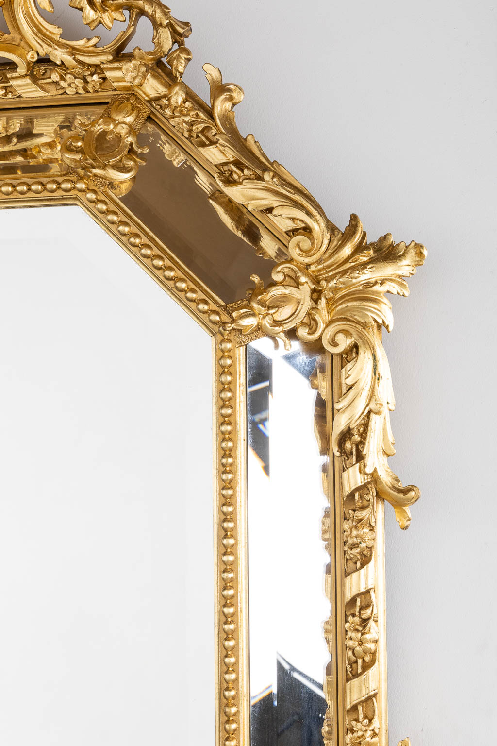 An antique mirror, sculptured gilt stucco and facetted glass, Louis XV style. 19th C. (W:98 x H:140 cm)