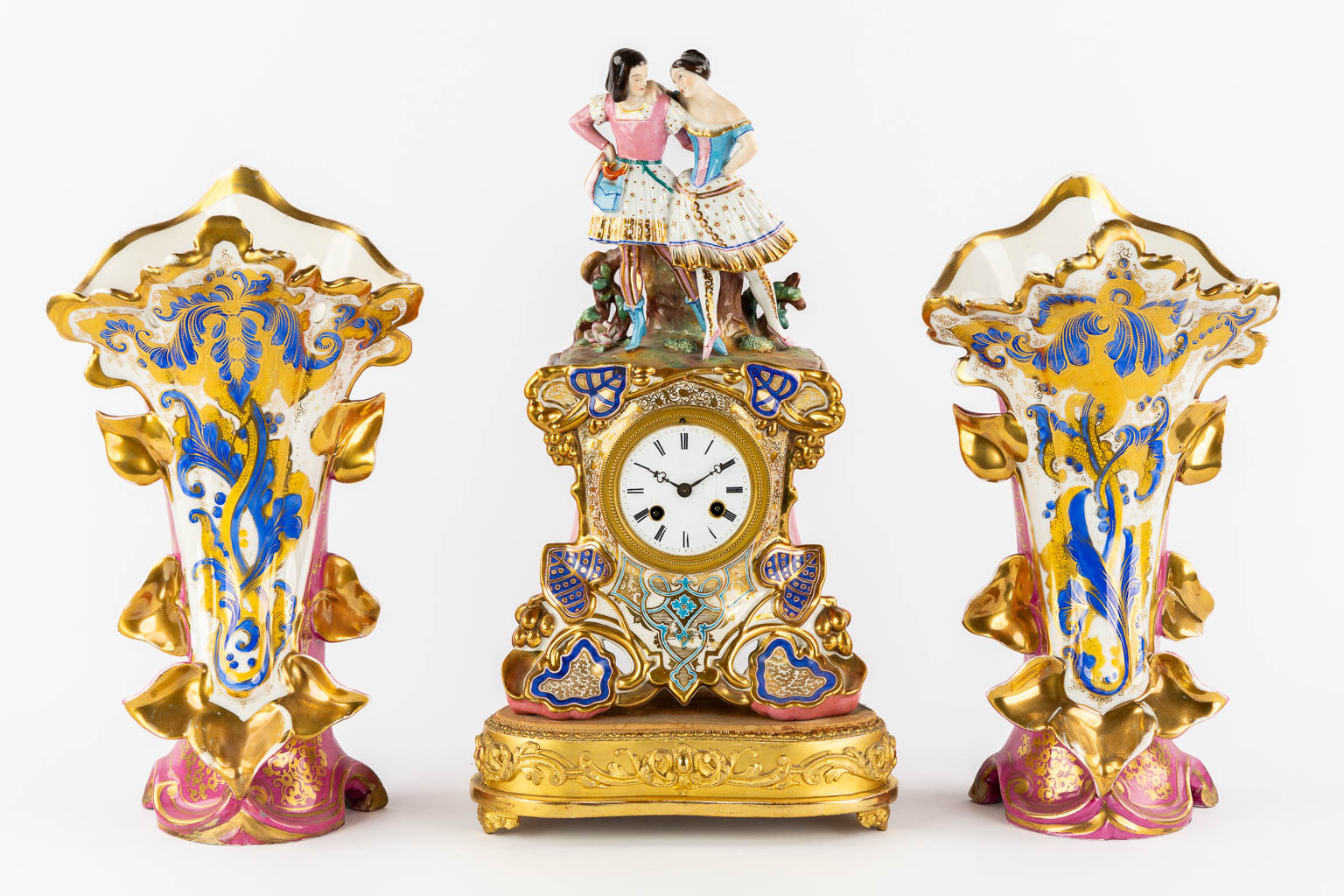 A three-piece mantle garniture clock and side pieces, polychrome porcelain in the style of Jacob Petit. 19th C.