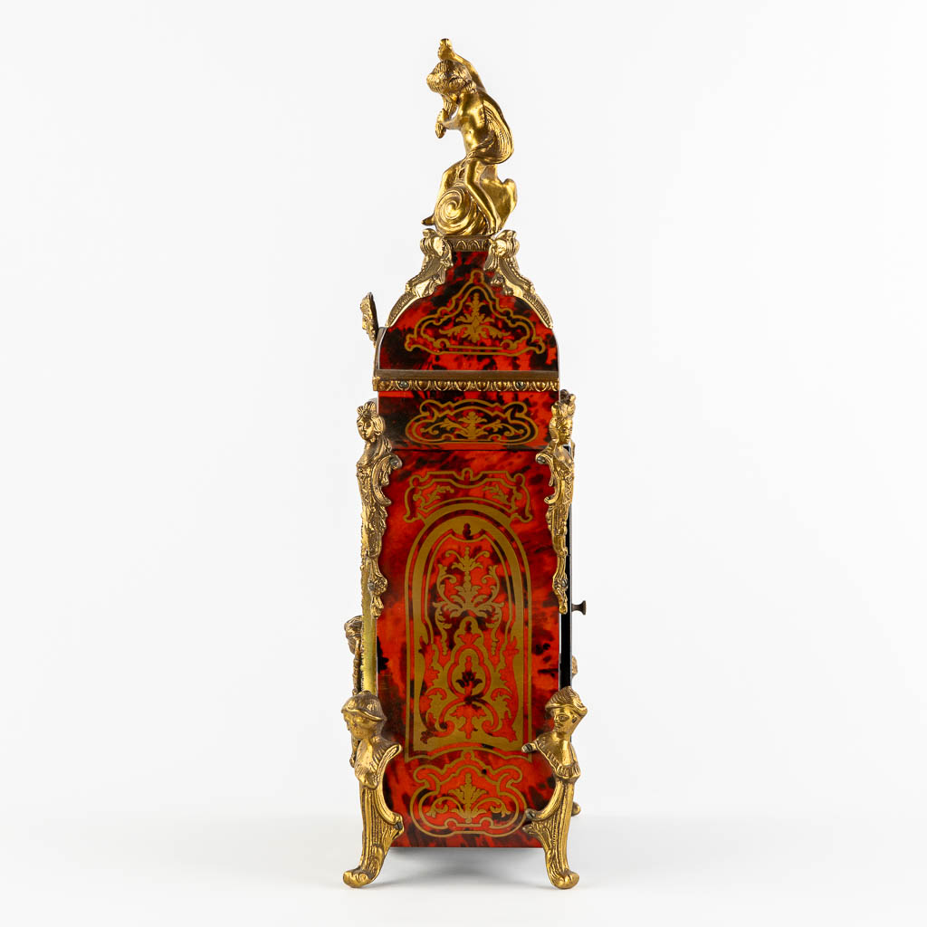 A mantle clock, boulle style marquetry inlay, mounted with gilt bronze. 20th C. (L:15 x W:32 x H:56 cm)