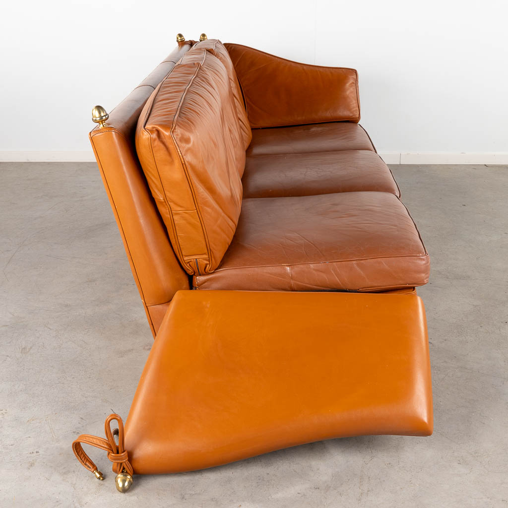 Een leder drie-persoon zetel in de stijl van Maison Jansen. (D:93 x W:240 x H:88 cm)