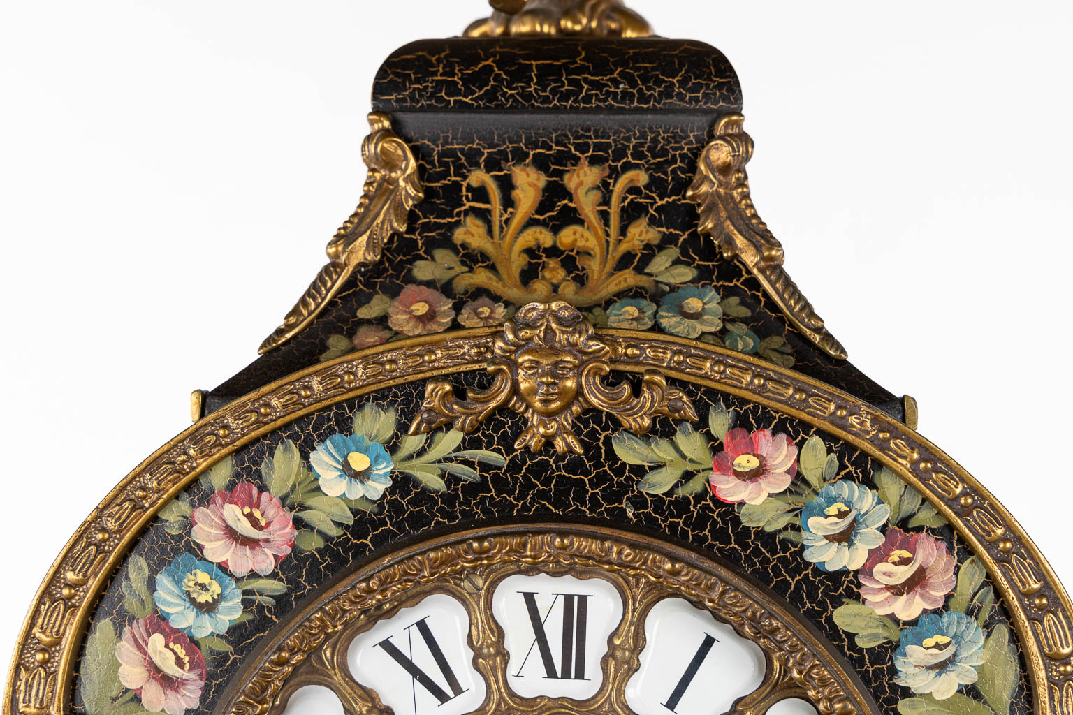 A cartel clock on a base, floral decor and mounted with putti. 20th C. (L:25 x W:44 x H:193 cm)