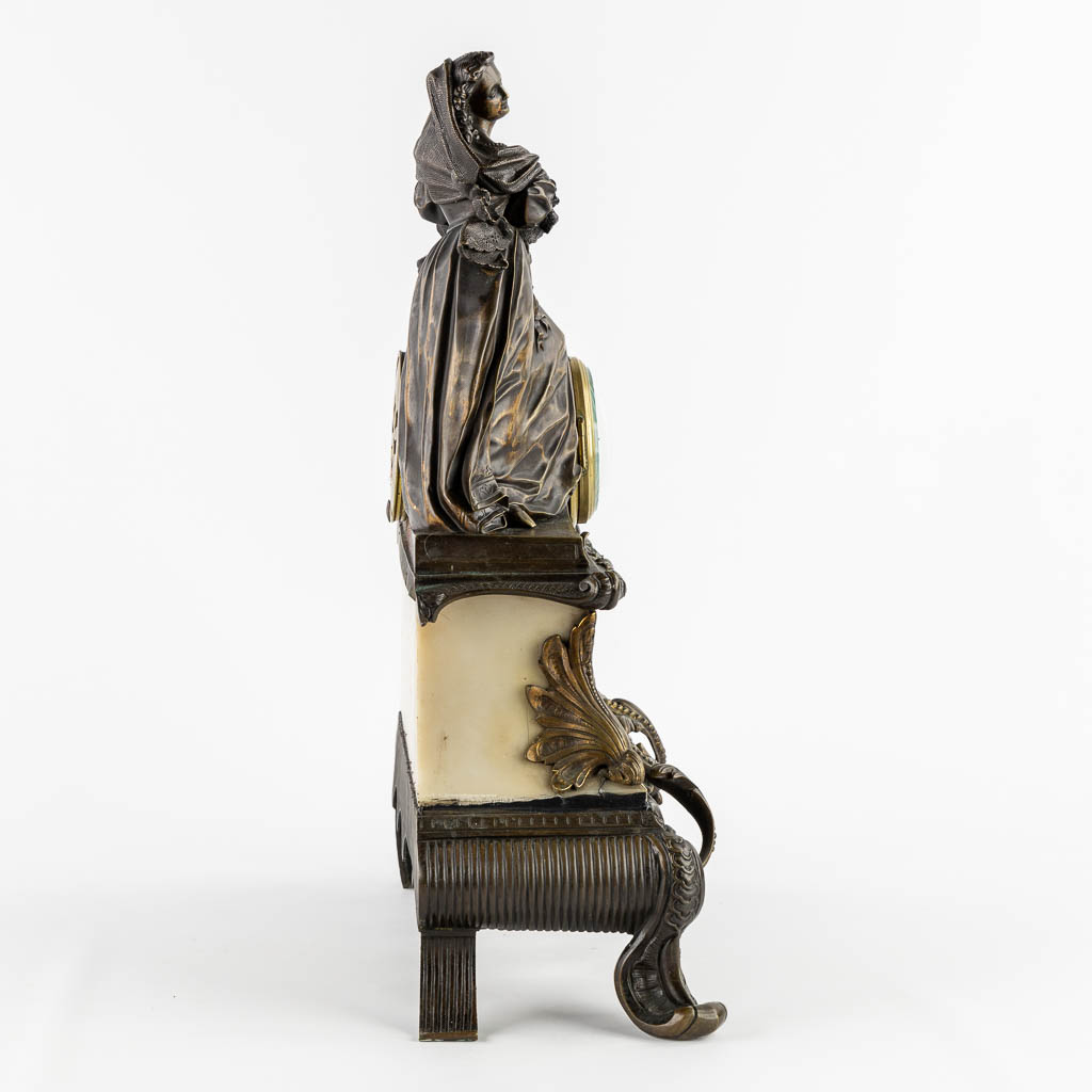 A mantle clock with a lady, patinated bronze on marble. (c.1900).