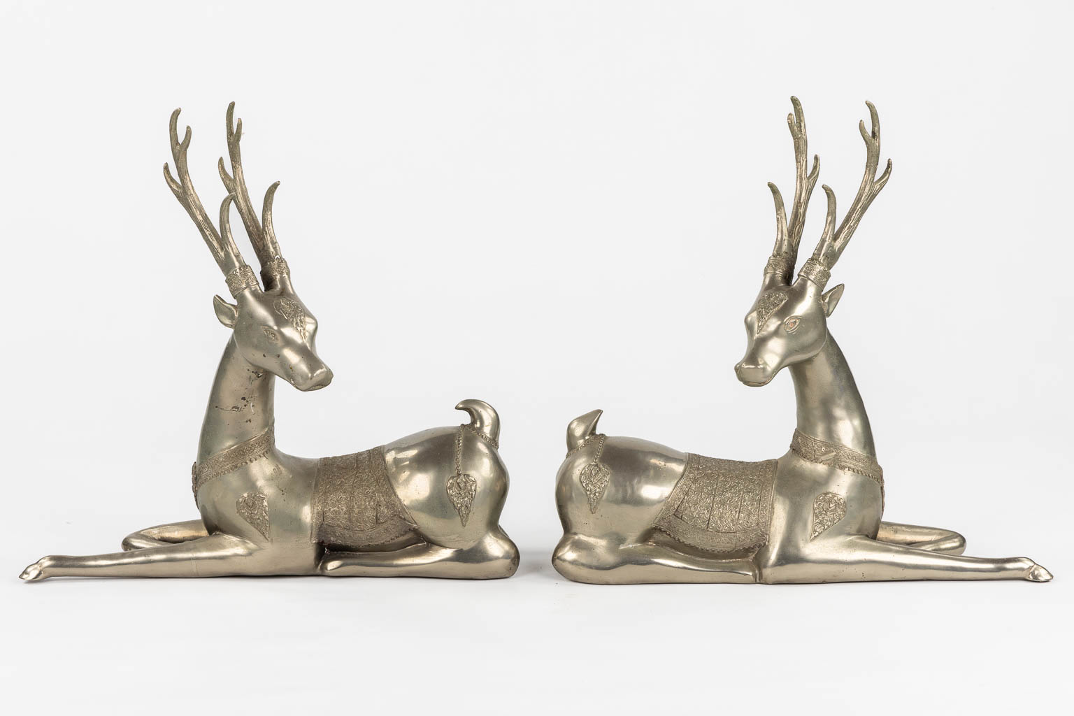 A pair of resting Temple Deer, silver-plated bronze. Circa 1970. (L:22 x W:51 x H:51 cm)