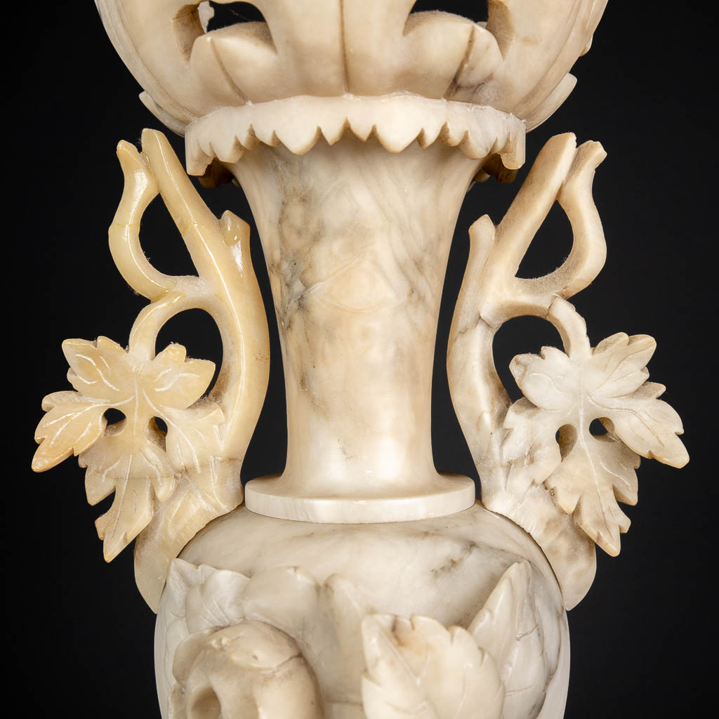 A three piece mantle garniture set, sculptured alabaster. (H:45 x D:15 cm)