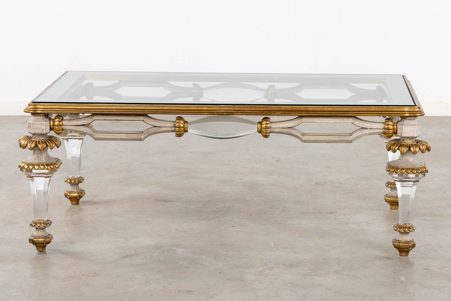 A Hollywood-Regency style coffee table, sculptured wood and plexiglass. (L:73 x W:120 x H:45 cm)