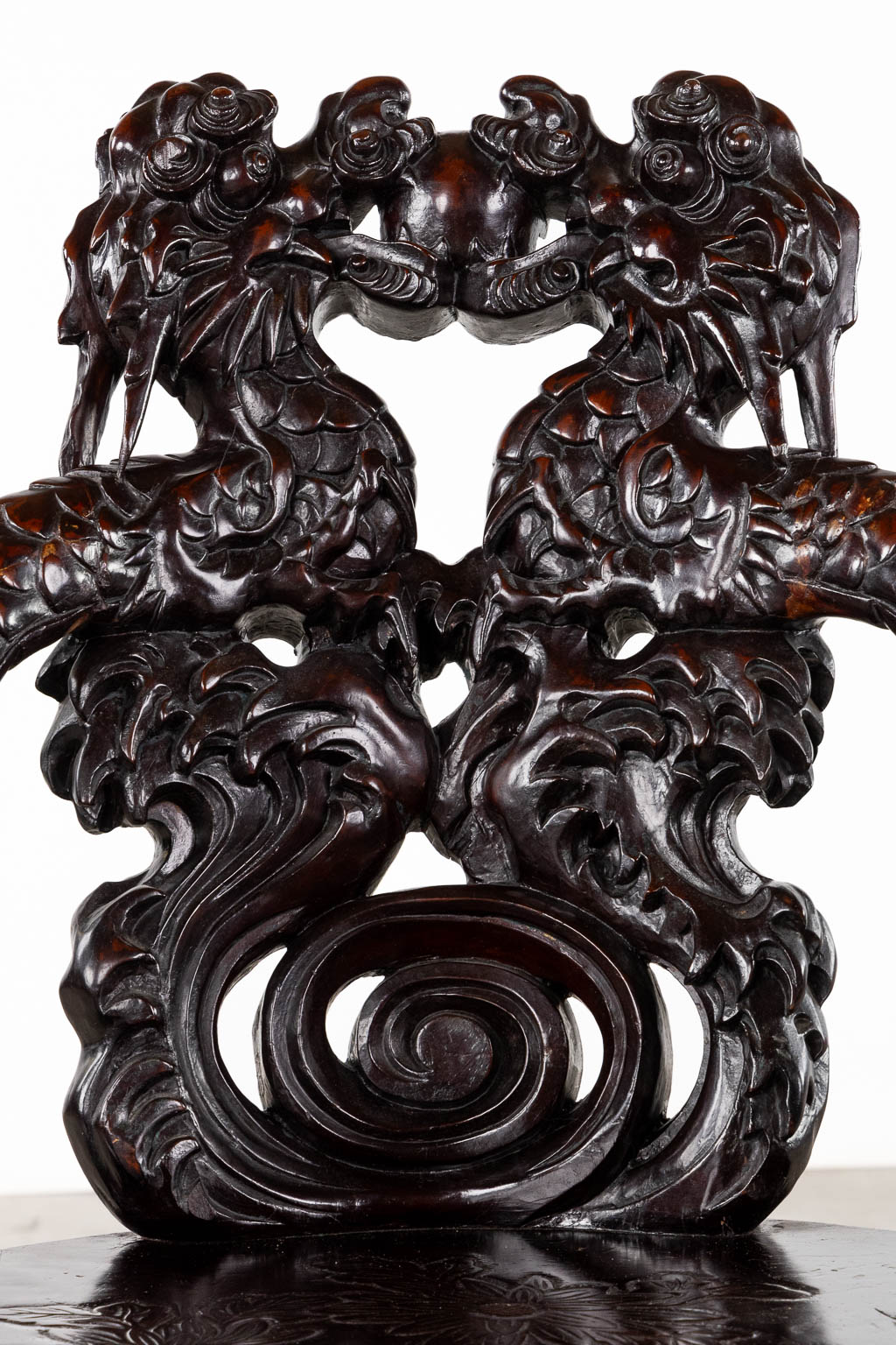 A Chinese sculptured hardwood armchair with a dragon decor. 