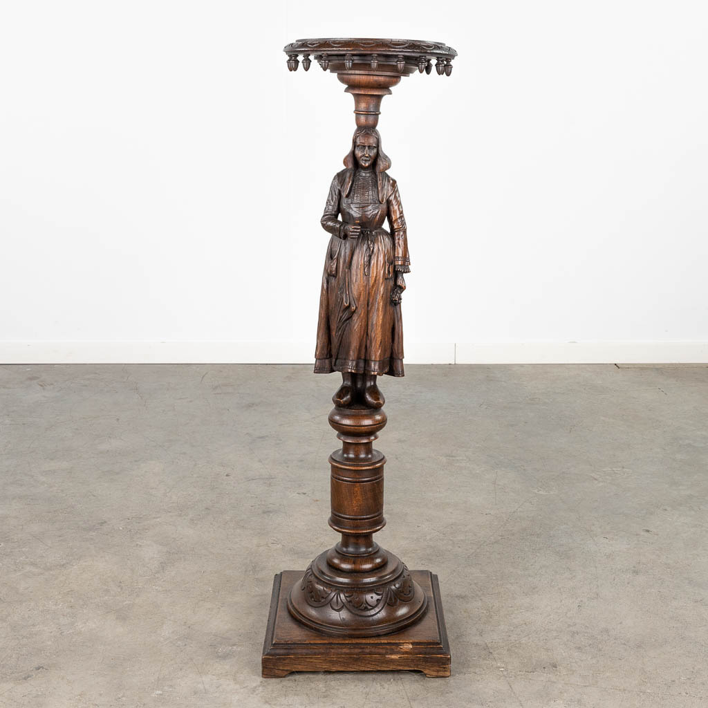 A pedestal with a wood sculptured figurine in Breton style. Circa 1900. (L: 31,5 x W: 31,5 x H: 107 cm)