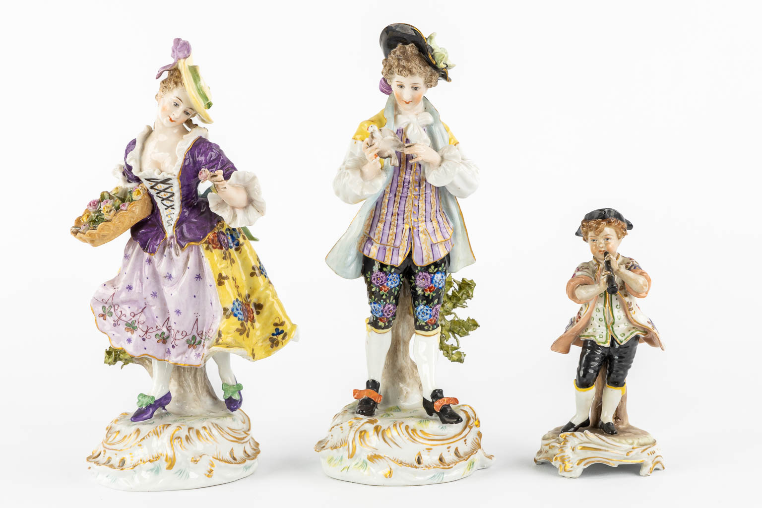 A pair of polychrome porcelain figurines, added A Saxony porcelain boy. (H:23,5 cm)