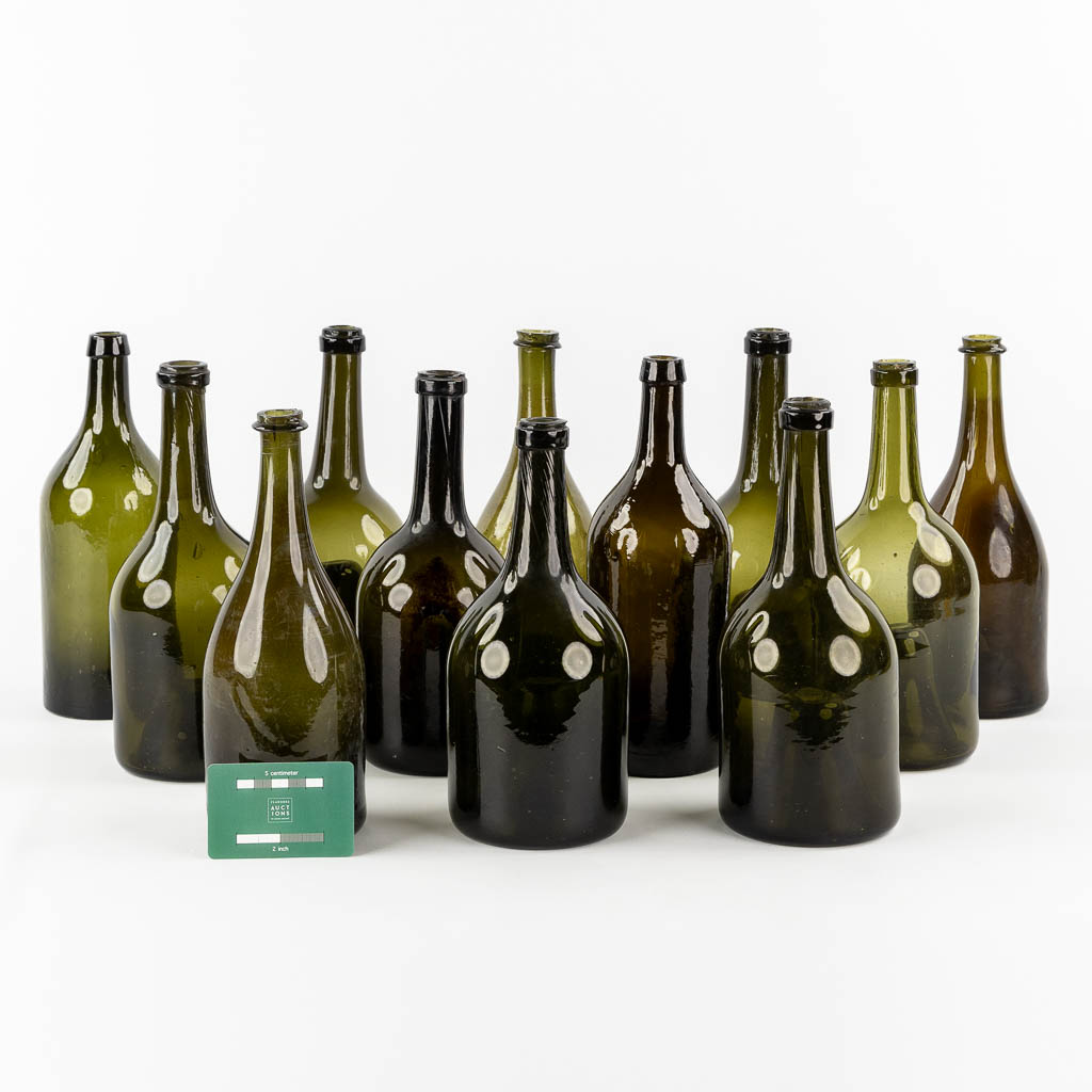 Twelve antique glass bottles, olive green glass. 18th and 19th C.