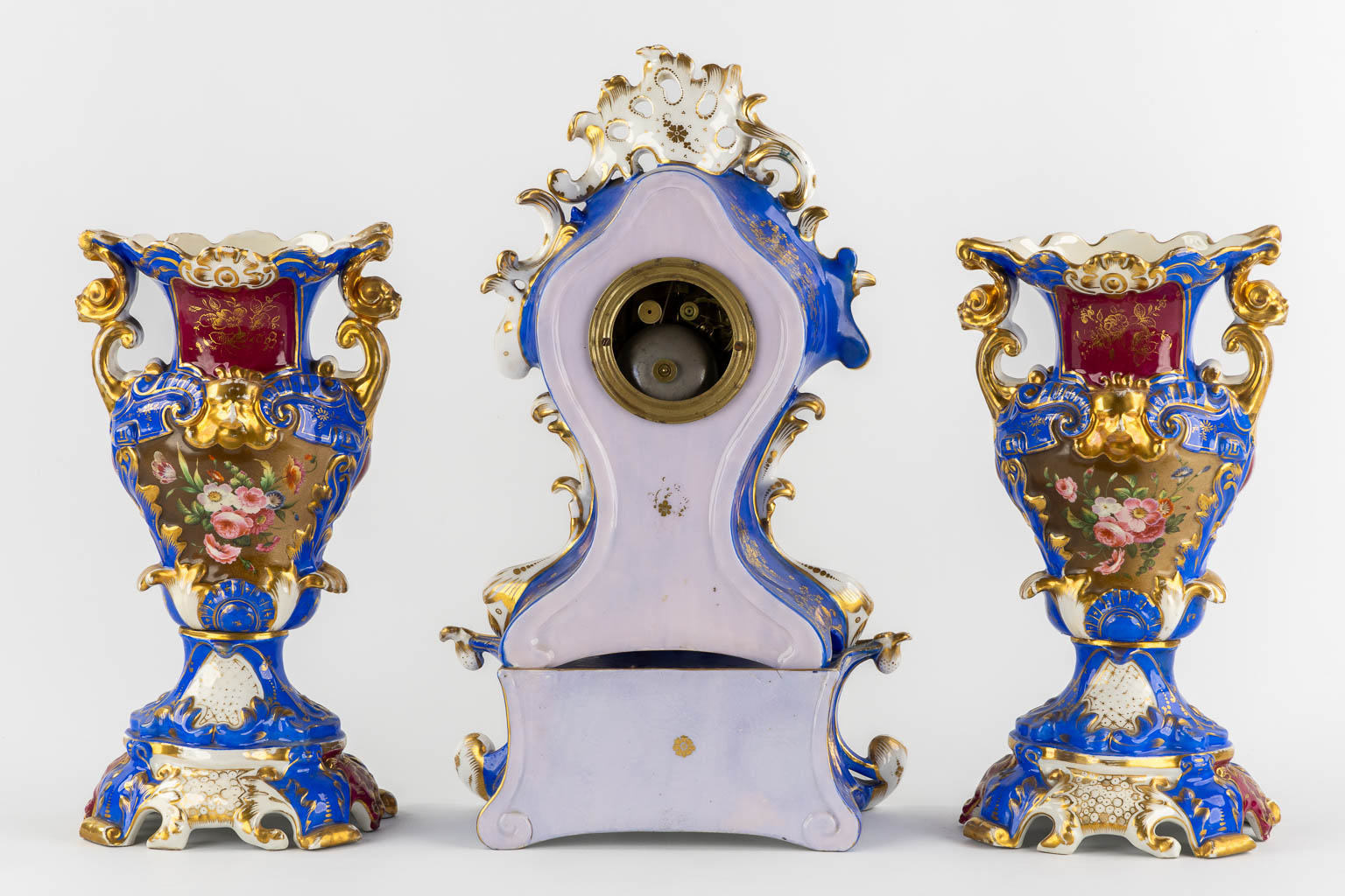 A Vieux Paris mantle clock with two side pieces, in the style of Jacob Petit. 19th C. (L:13 x W:25 x H:41 cm)