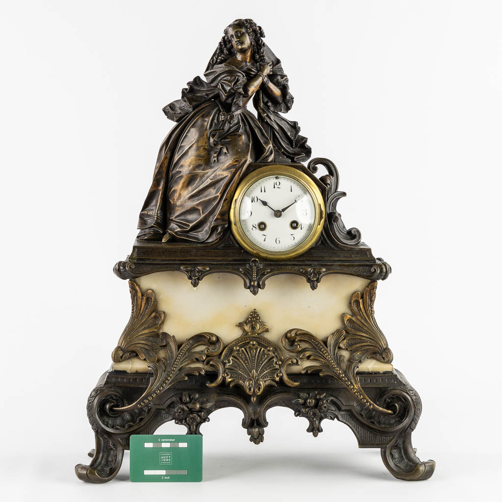 A mantle clock with a lady, patinated bronze on marble. (c.1900).