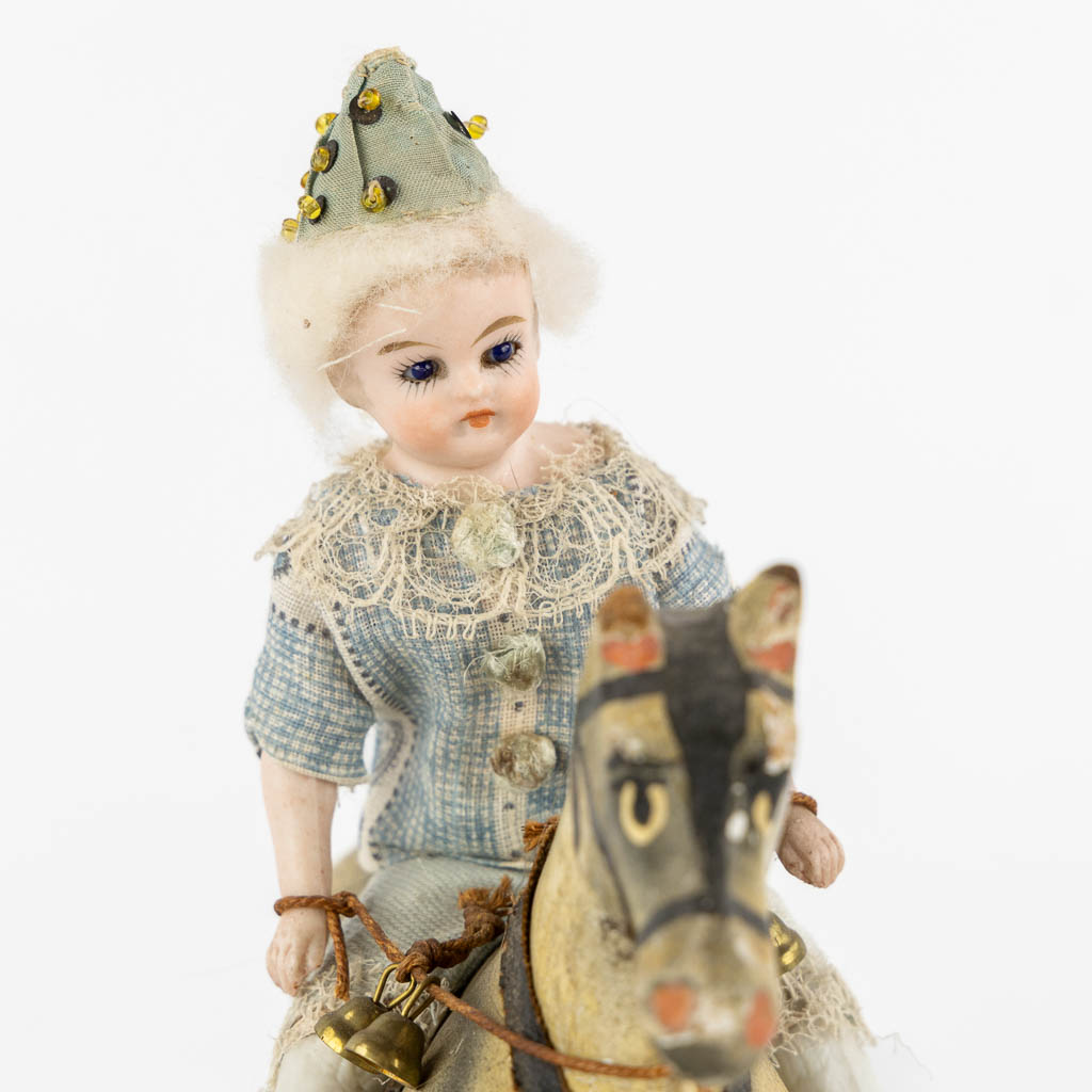 Kinderspeelgoed, een figuur van een Mignonette op een paard, bijgevoegd een Lama. (H:22 cm)